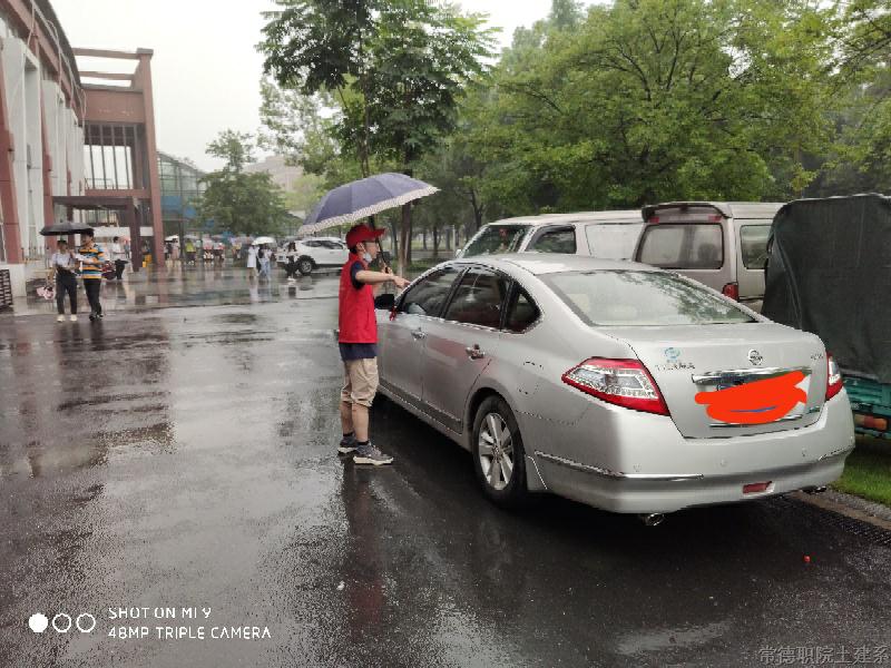 党员志愿者正在院办公楼前劝导规范停车.png 党员志愿者正在院办公楼前劝导规范停车.png